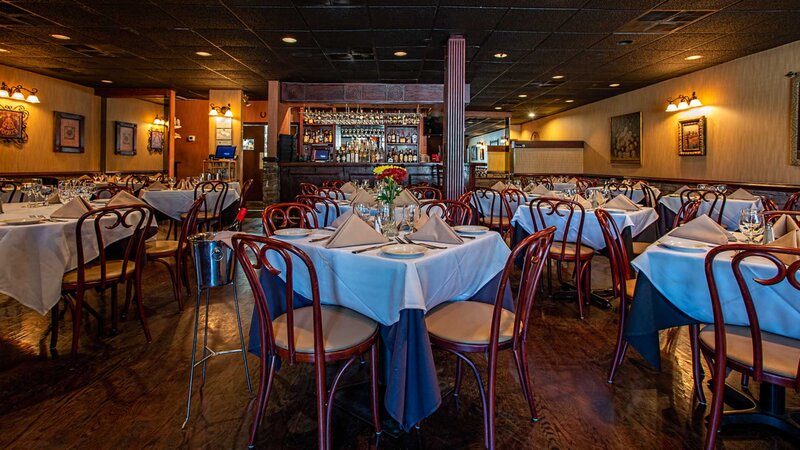 Dining room with many set tables with view of bar